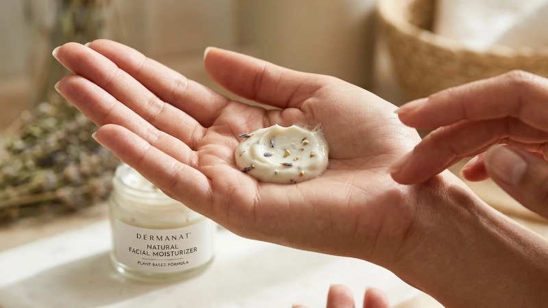 Palm holding natural facial moisturizer with botanical fleck